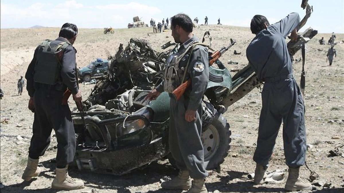Oficiales de seguridad afganos inspeccionan la zona donde se ha producido un ataque con bomba contra un furgón policial en Pekara (Afganistán) hoy, 18 de abril de 2011. EFE
