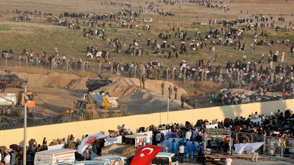 Los soldados turcos impiden entrar a los refugiados mientras los terroristas les disparan al otro lado