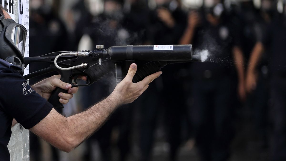 Policía apunta con un arma a los manifestantes en Ankara