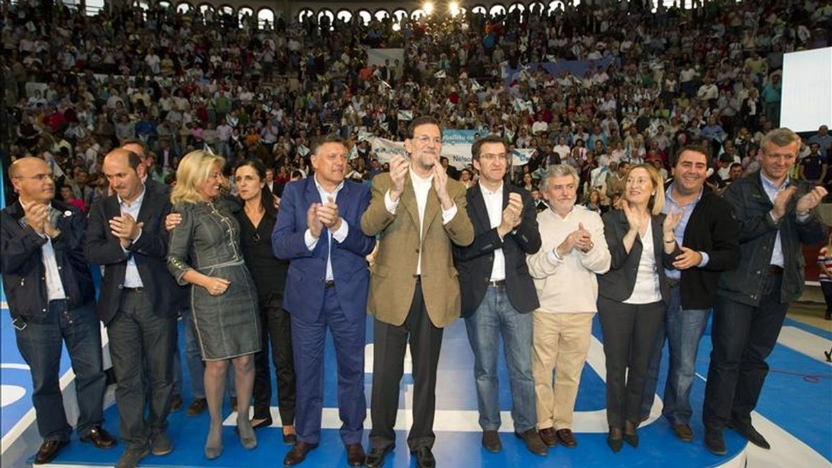 El presidente del PP, Mariano Rajoy (c) posa junto al máximo responsable del partido en Galicia, Alberto Núñez Feijóo (5d), entre otros asistentes, durante el acto de la precampaña para las próximas elecciones municipales que se ha celebrado esta tarde en la plaza de toros de Pontevedra. EFE