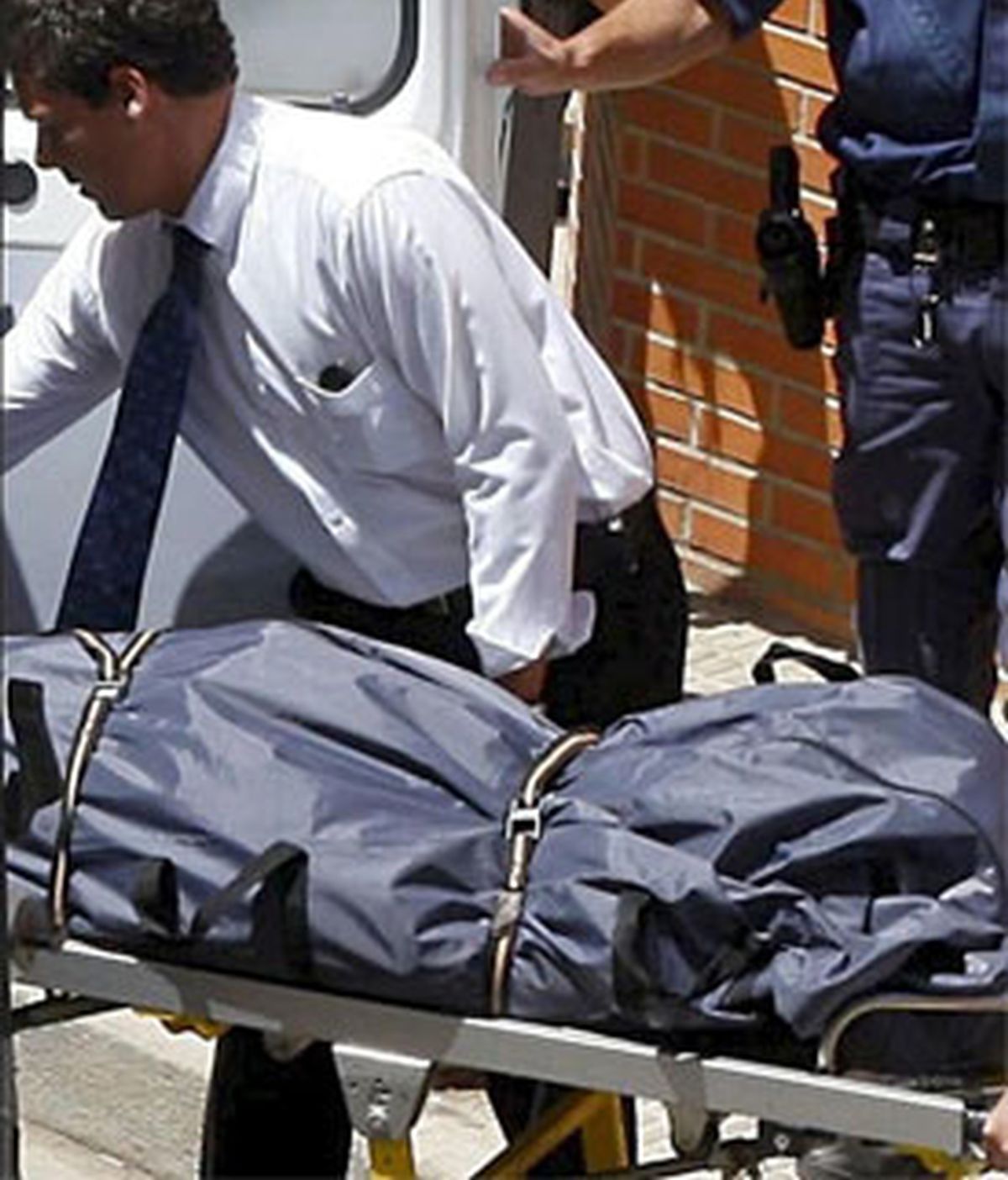 Empleados de los servicios funerarios trasladan el cadáver de una víctima de violencia machista. EFE/Archivo