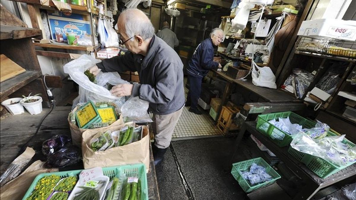 Un vendedor de verduras comprueba cajas con mercancía en un puesto del mercado de Tsukiji en el centro de Tokio (Japón). EFE/Archivo