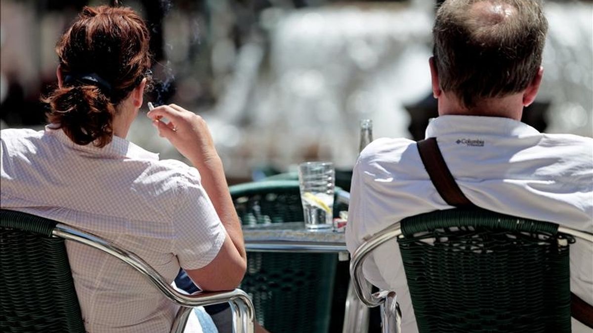 Una mujer fuma este mediodía sentada en una terraza de Valencia. EFE