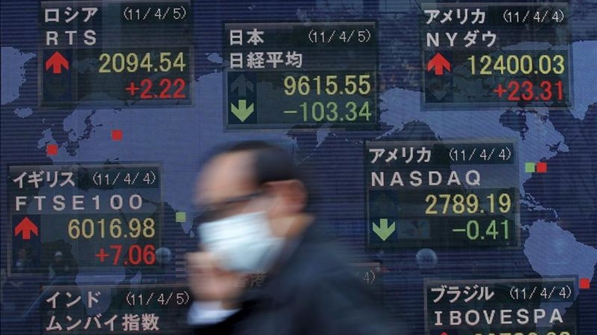 Un hombre camina frente a un tablero electrónico con los resultados de la Bolsa de Tokio (Japón). EFE/Archivo