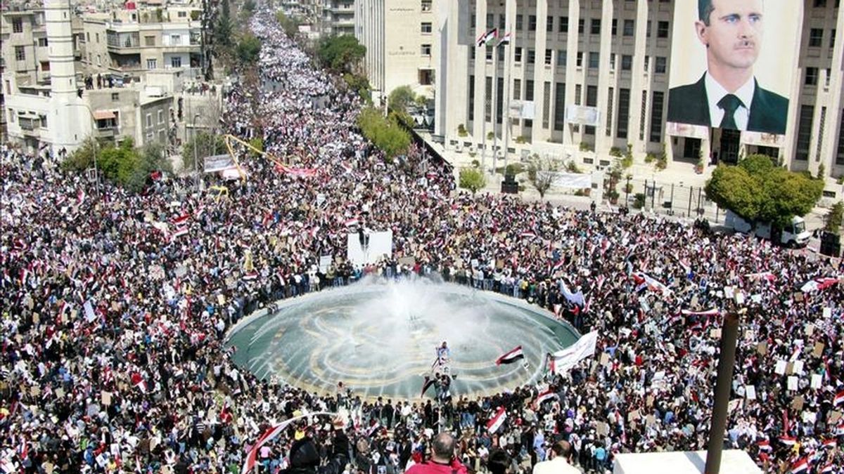 Decenas de miles de personas muestran su apoyo al presidente sirio, Bashar al Asad (en el póster), durante la manifestación celebrada en la céntrica plaza de Sabe Barat, en Damasco (Siria), hoy, martes, 29 de marzo de 2011. EFE