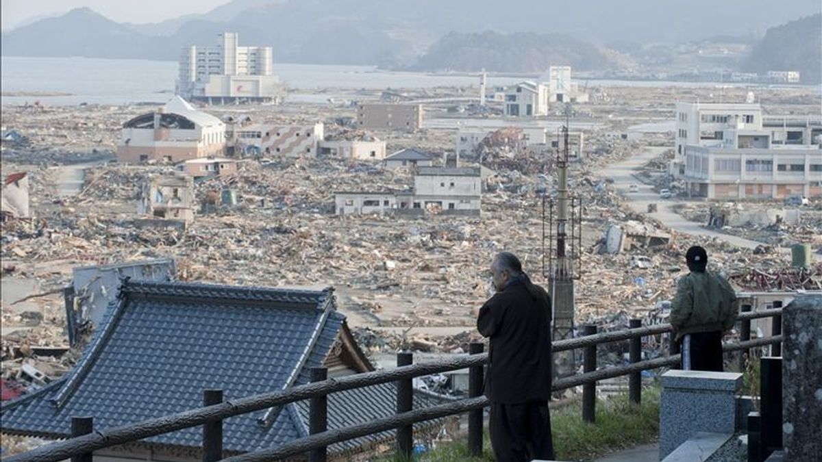 Foto facilitada ayer que muestra a dos japoneses observando el devastador paisaje que presenta la localidad de Rikuzentakada, en la prefectura de Iwate, noreste de Japón, tras el terremoto de 9 grados y tsunami del pasado 11 de marzo. EFE