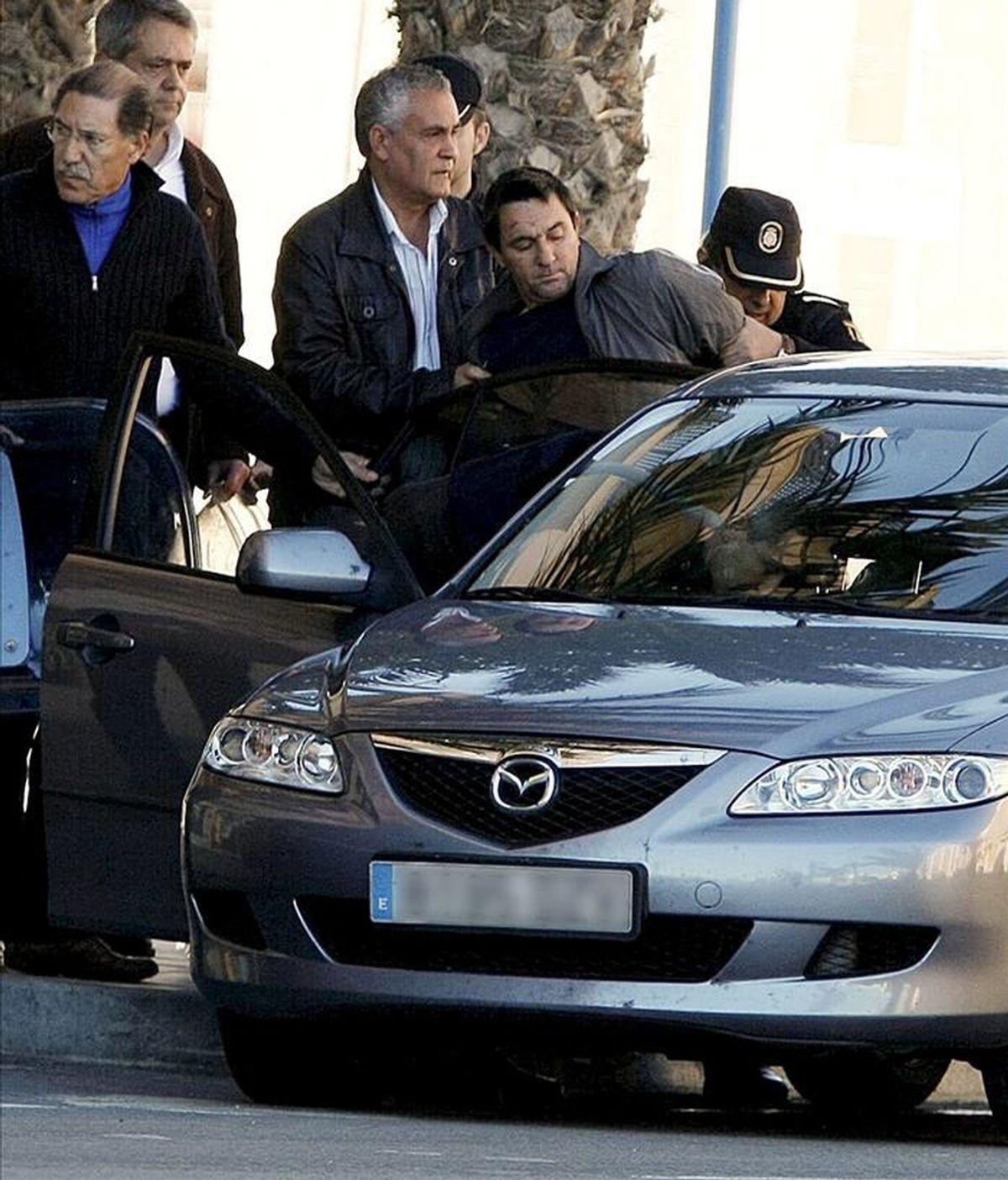 Agentes policiales introducen en el interior de un vehículo al hombre que se había encerrado en un sucursal bancaria de Alicante y que mantenía retenida bajo amenaza a una persona, al parecer, el director del banco, quien ha sido liberado minutos antes del arresto. EFE Agentes policiales introducen en el interior de un vehículo al hombre que se había encerrado en un sucursal bancaria de Alicante y que mantenía retenida bajo amenaza a una persona, al parecer, el director del banco, quien ha sido liberado minutos antes del arresto. EFE
