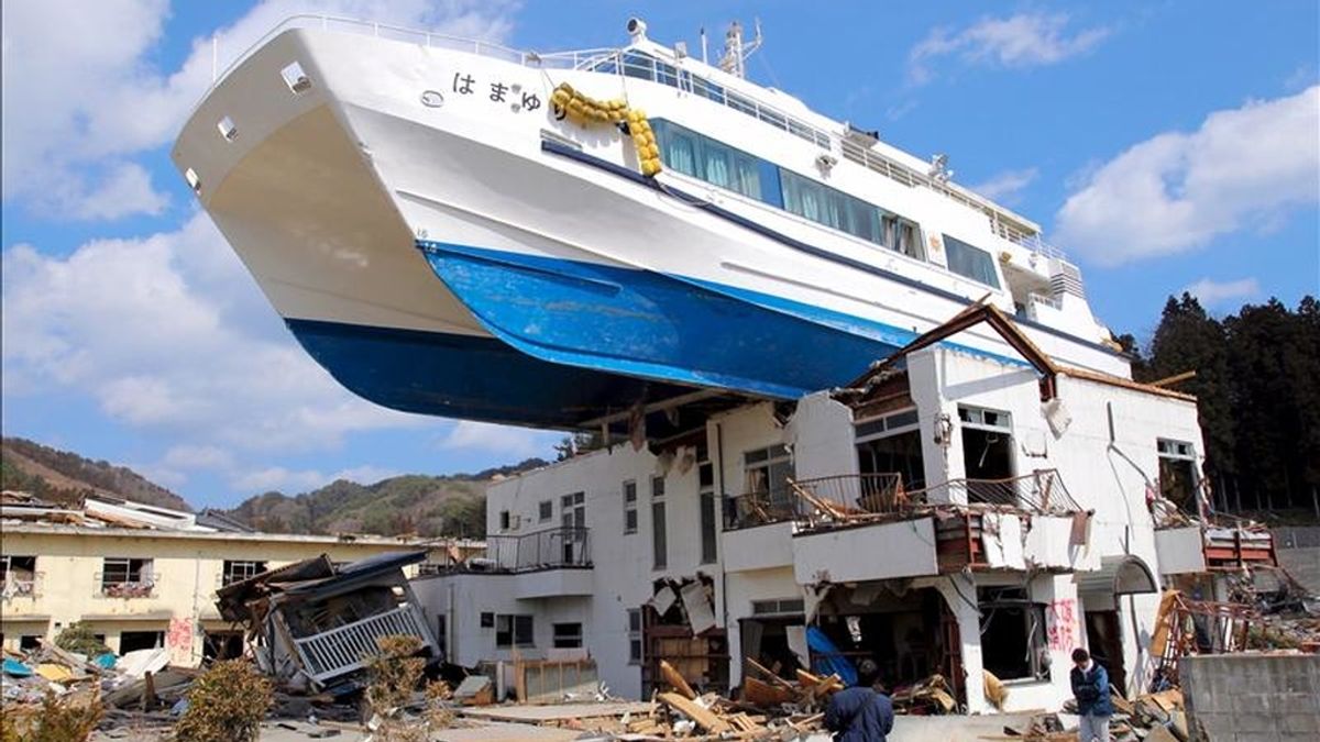 Un superviviente se detiene ayer ante un yate literalmente apoyado sobre el tejado de una casa en ruinas, en el puerto de Otsuchi, en la prefectura de Iwate. EFE