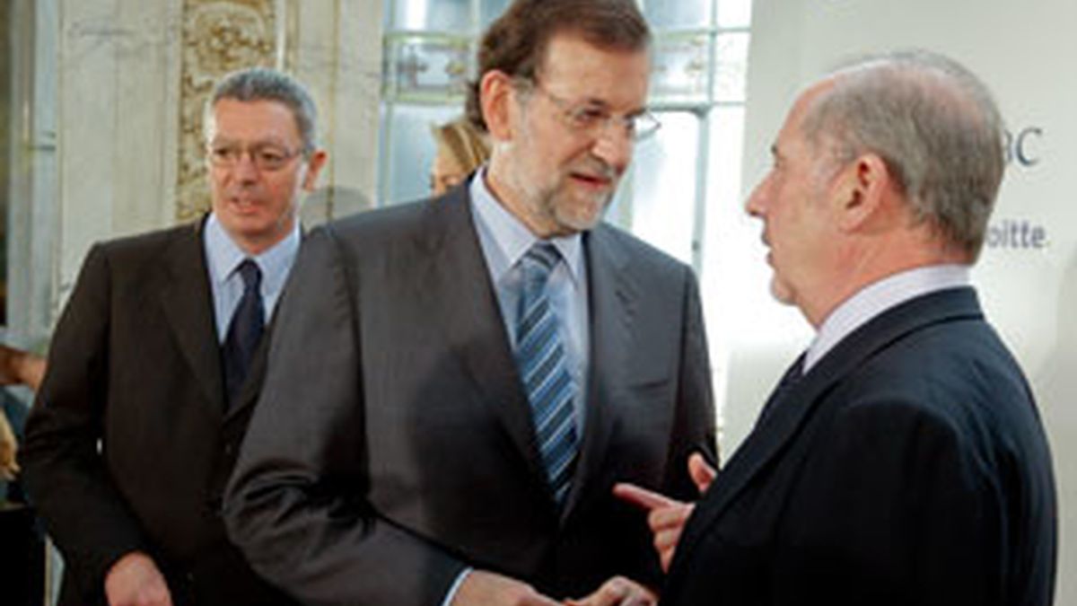 Mariano Rajoy conversa con el presidente de Bankia, Rodrigo Rato, en presencia del alcalde de Madrid. Foto: EFE.