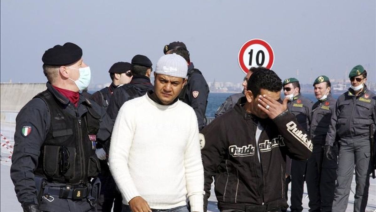 Parte de los 1.700 inmigrantes que llegaron en ferry desde la isla de Lampedusa a la base Mar Grande, antes de ser trasladados a un campamento levantado a unos 6 km de Manduria, cerca de Taranto, hoy, viernes 1 de abril de 2011. EFE