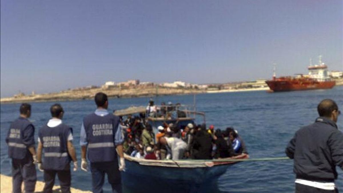 Guardacostas italianos esperan la llegada de uno de las seis embarcaciones procedentes de Libia que llegaron a Lampedusa. EFE