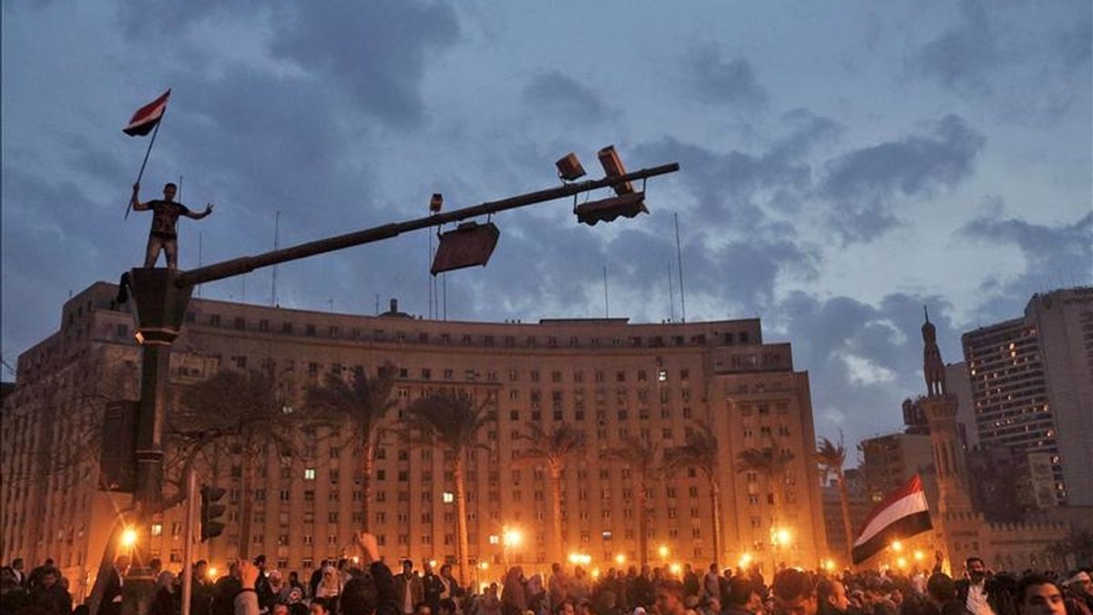 Un manifestante portando una bandera egipcia sobre un semáforo, durante una manifestación en la plaza Al Tahir en el centro de El Cairo. EFE