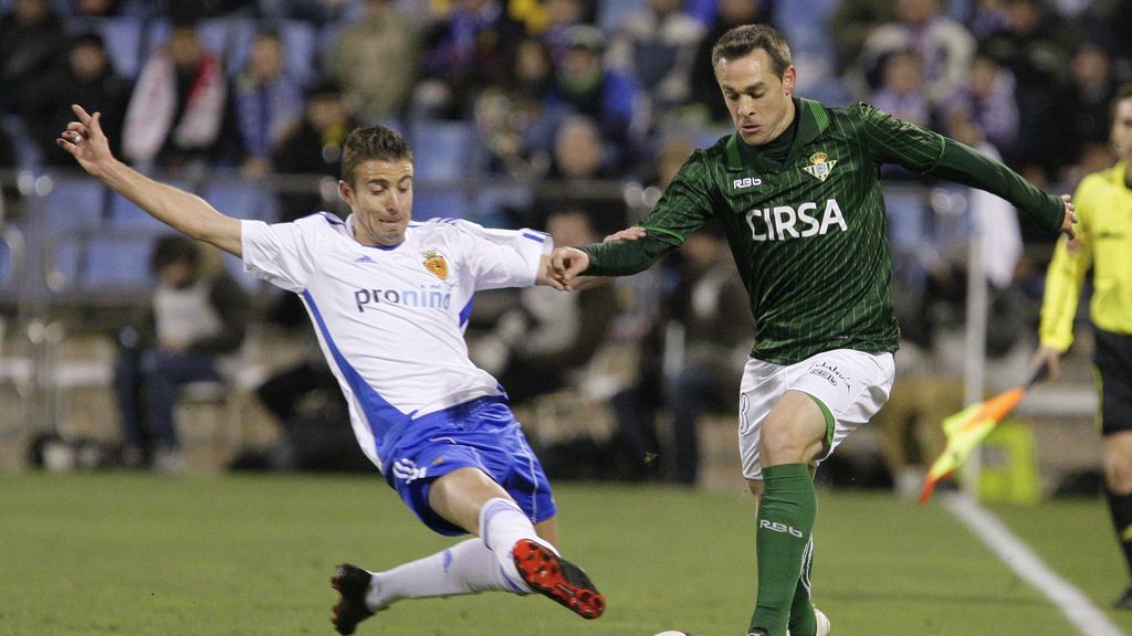 El betico Nacho se lleva el balón ante la entrada del delantero del Real Zaragoza Luis García