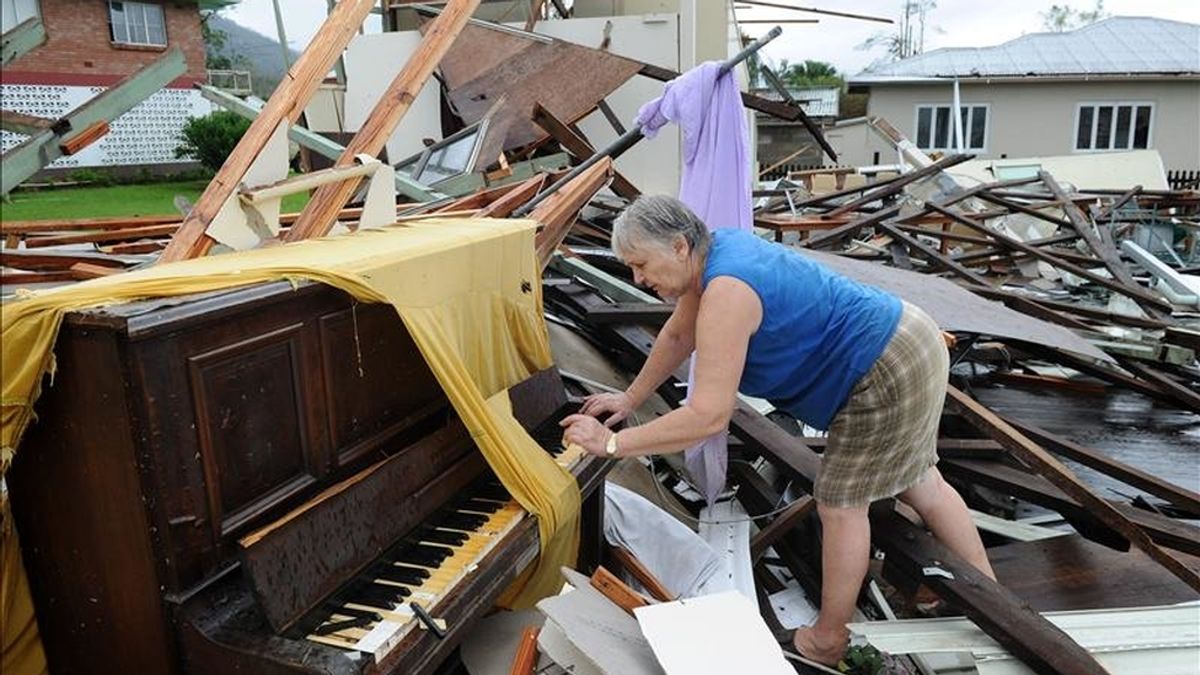 Una mujer sobre el piano que alguna vez estuvo en el club Tully Senior Citizens, en la localidad de Tully (Australia). Residentes están de regreso a sus casas devastadas después del paso de "Yasi". EFE