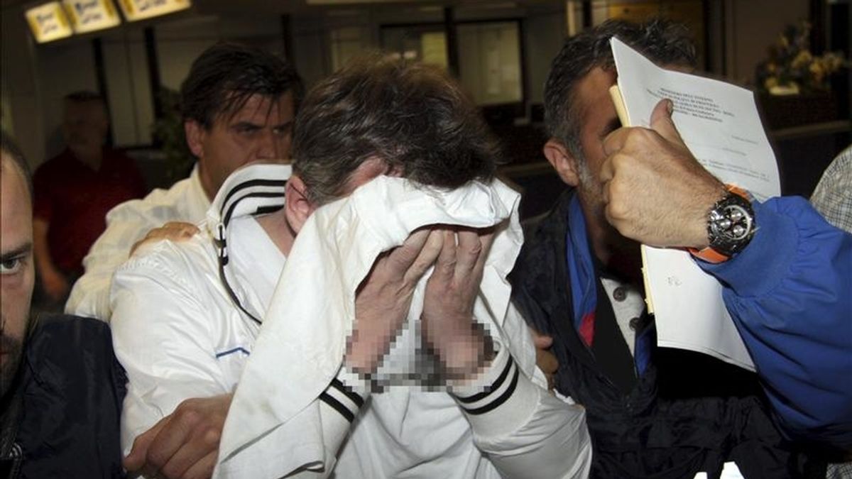 El kazajo Valeriy Tolmachev (centro) es escoltado por la policía en el aeropuerto de Fiumicino al noreste de Roma (Italia) hoy, lunes, 25 de abril de 2011. EFE
