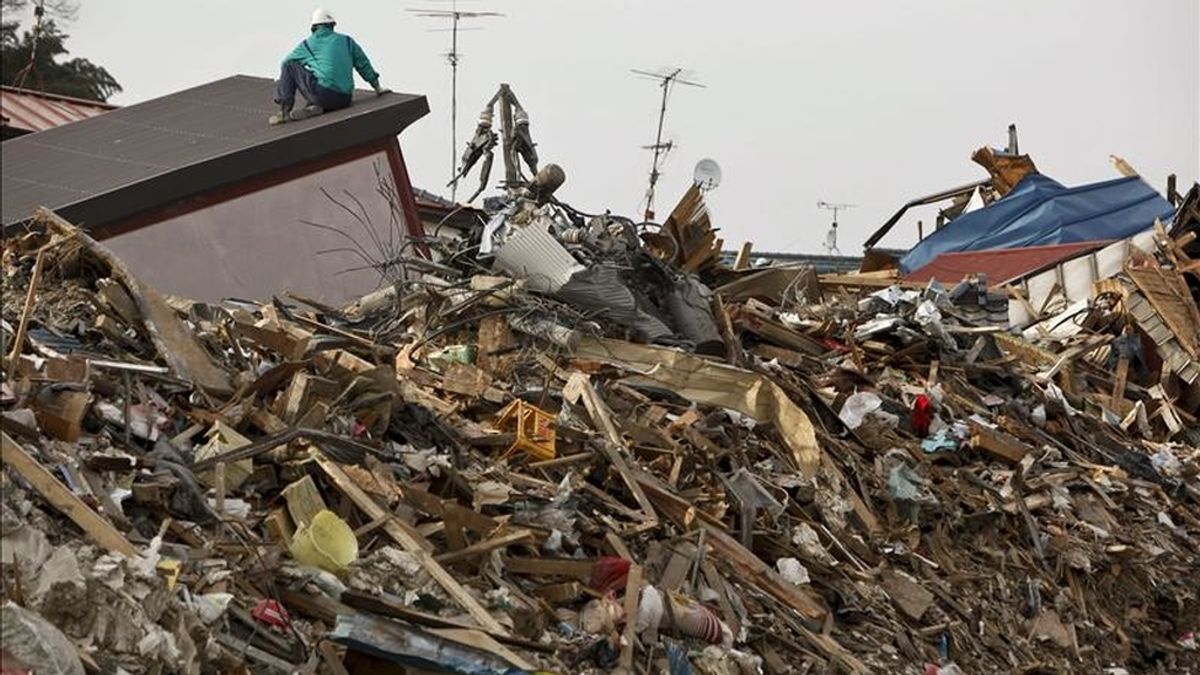Un hombre se sube a una montaña de escombros en la devastada ciudad de Ishinomaki, en la prefectura de Miyagi (Japón). EFE