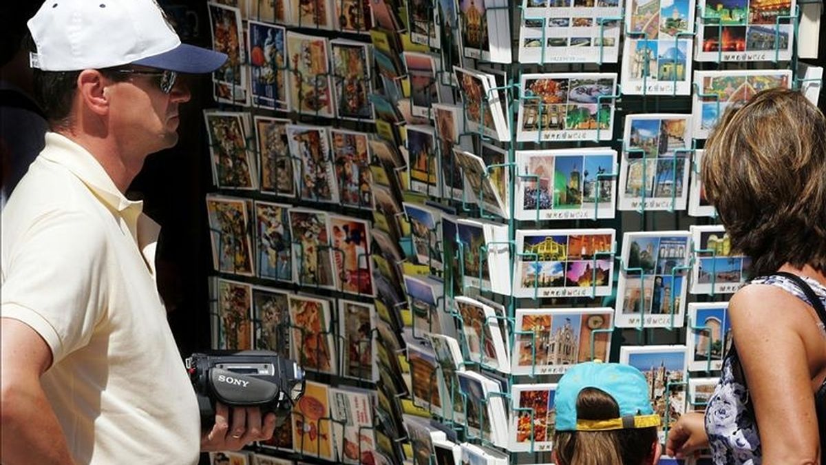 En la imagen, unos turistas observan varias de las postales que se encuentran colgadas en una tienda de Valencia. EFE/Archivo En la imagen, unos turistas observan varias de las postales que se encuentran colgadas en una tienda de Valencia. EFE/Archivo