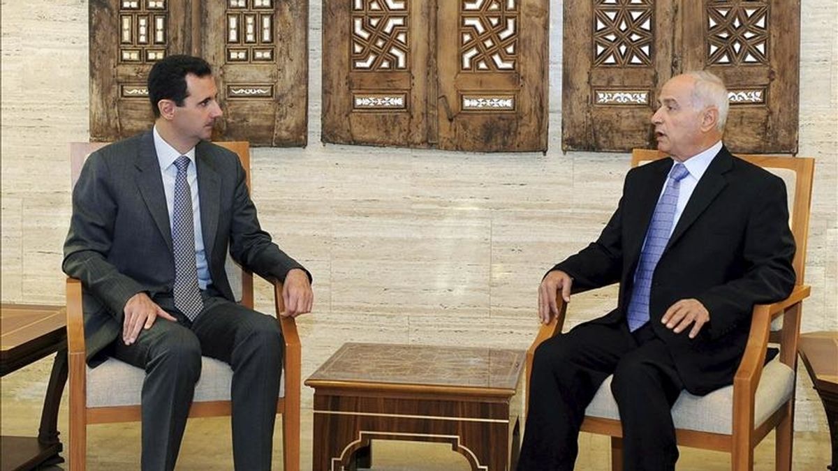 Fotografía facilitada por la agencia siria de noticias SANA que muestra al presidente sirio, Bachar al Asad, charlando con el nuevo gobernador en la provincia de Homs, Gasal Mustafa Abdelal, al que Asad nombró en su cargo. EFE