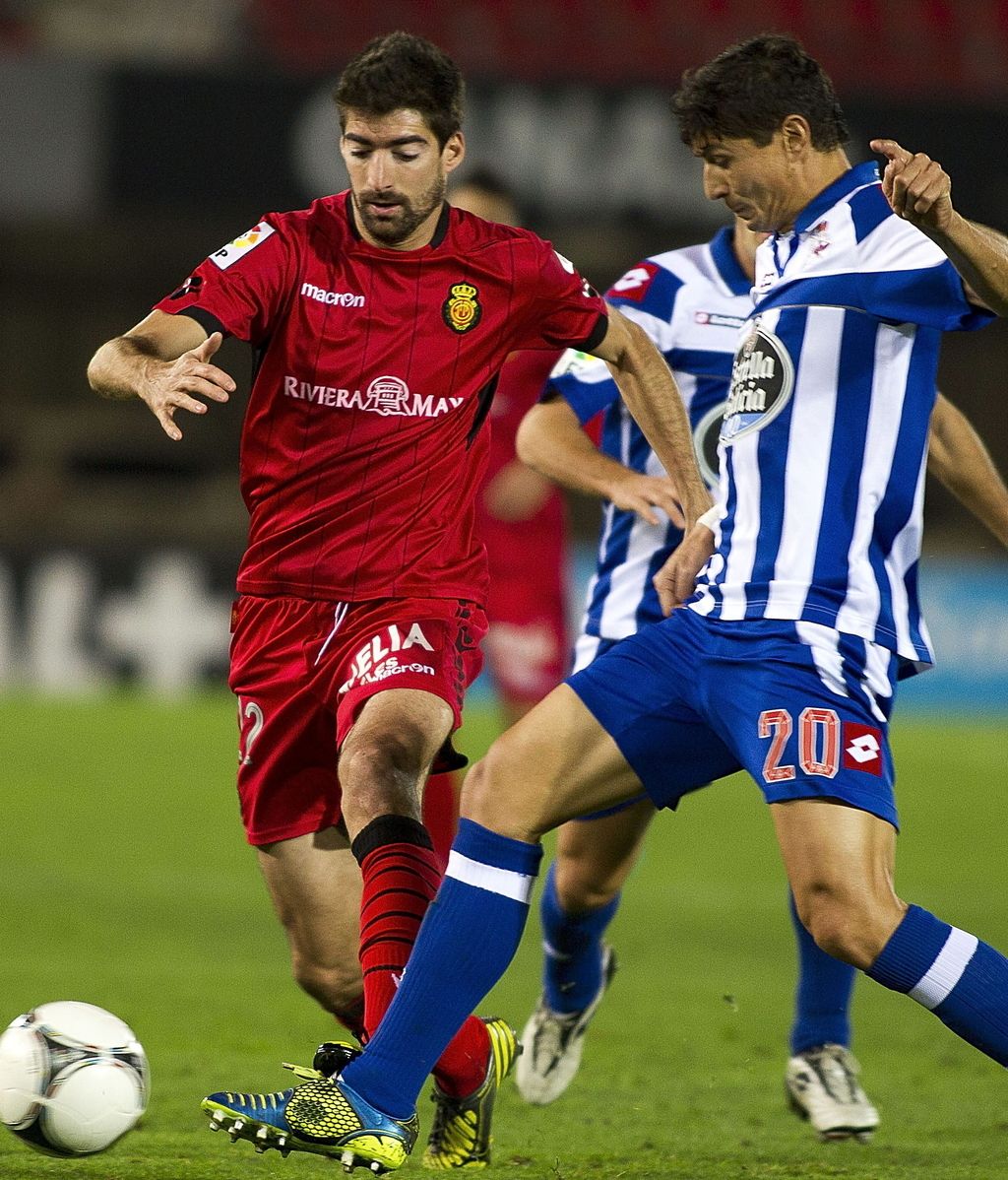 El delantero del RCD Mallorca Ángel Javier Arizmendi (i) trata de escapar de Jesús Vázquez (d), del Deportivo de La Coruña
