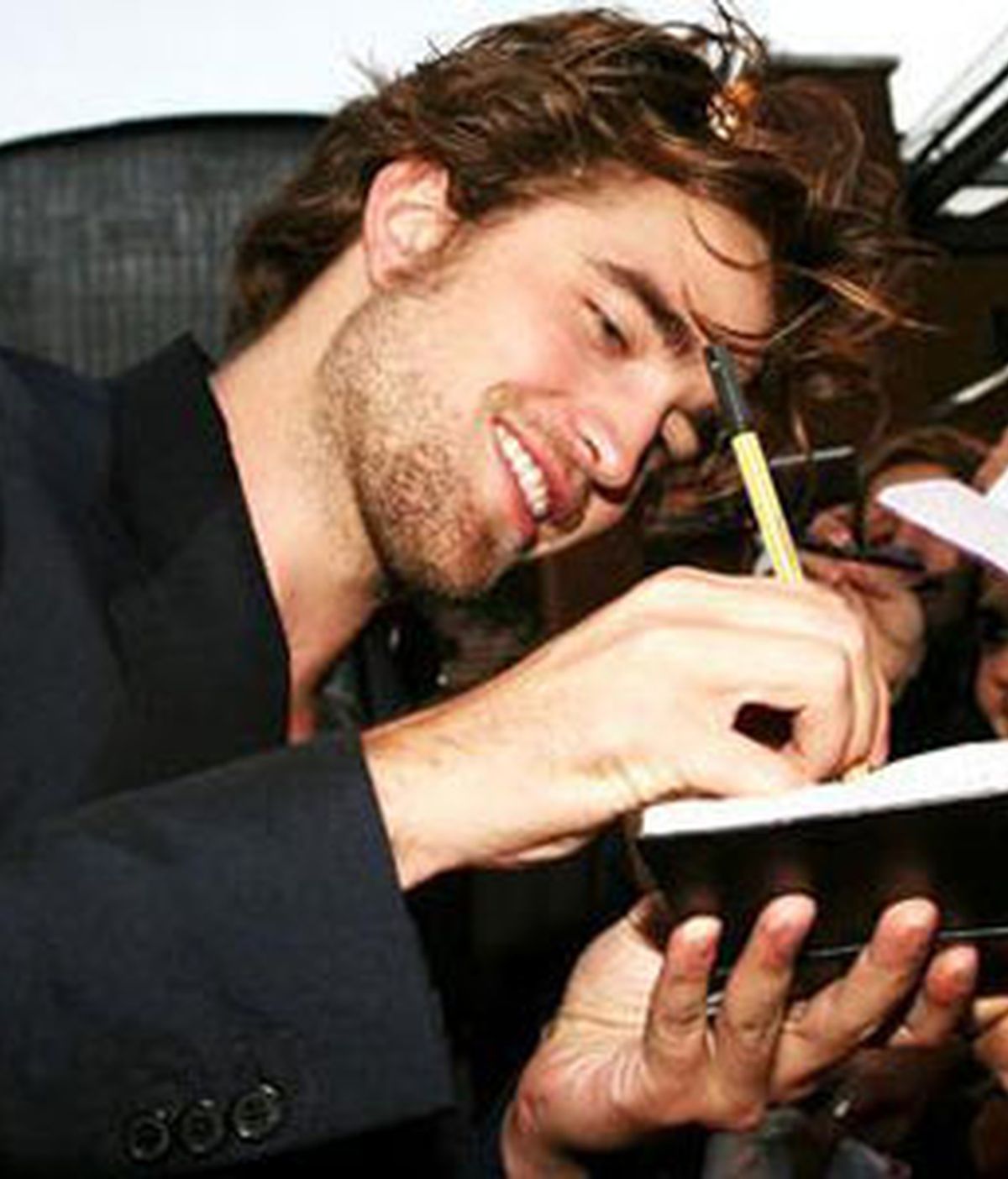 Robert Pattinson firmando autógrafos a sus fans