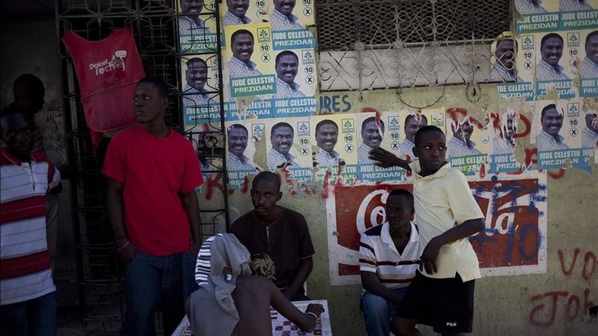 Varios jóvenes permanecen junto a carteles electorales del candidato presidencial del partido Inite, Jude Celestin, en Puerto Príncipe (Haití). EFE/Archivo