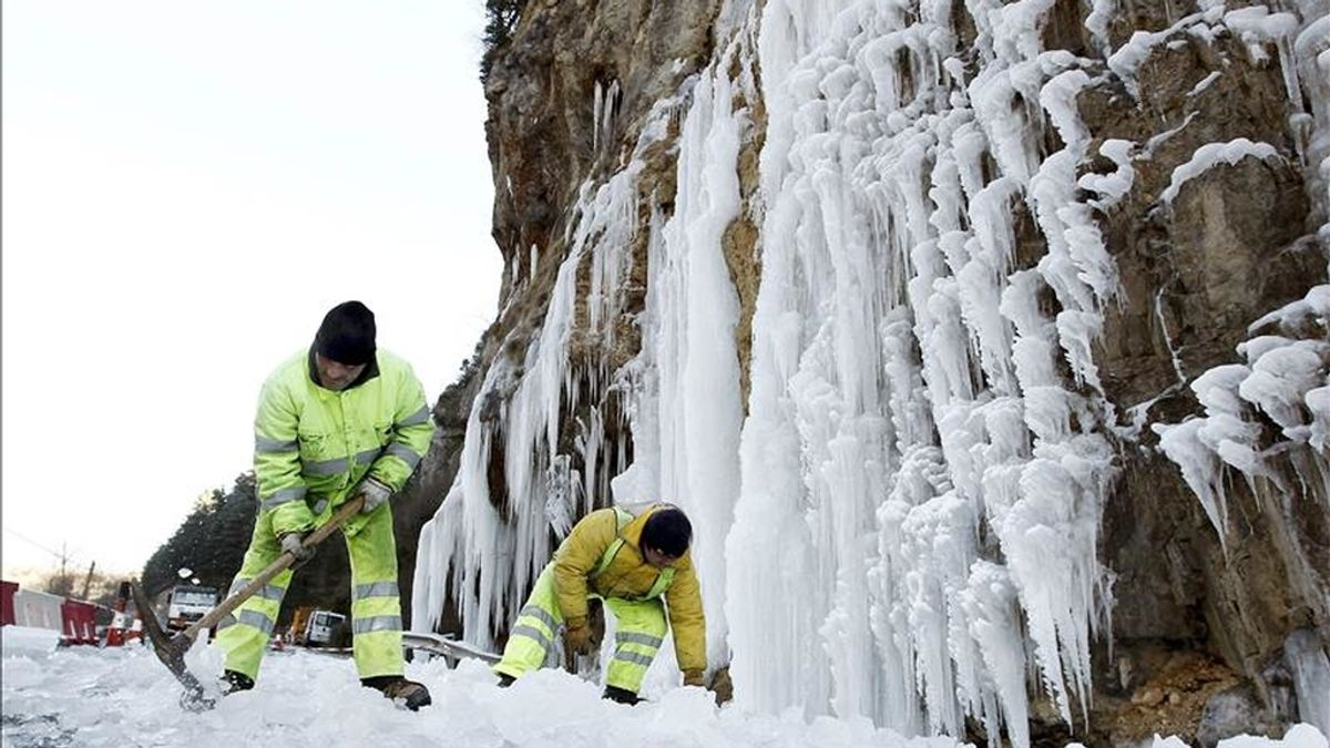 Operarios del servicio de conservación de carreteras intentan quitar algunos de los trozos de hielo que han caido de una cascada formada sobre la NA-137, y que ha obligado a cortar uno de los carriles de la carretera ante el peligro que supone el desprendimiento de los carámbanos formados por las temperaturas bajo cero. EFE