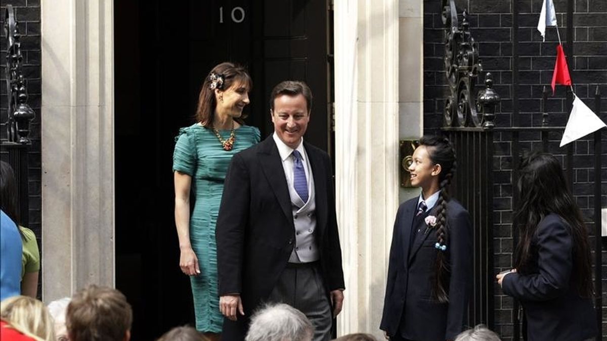 El primer ministro británico, David Cameron (c), y su esposa, Samantha (izda), asisten a una fiesta ante el número 10 de Downing Street para celebrar la boda real entre el príncipe Guillermo y Catalina, duques de Cambridge. EFE