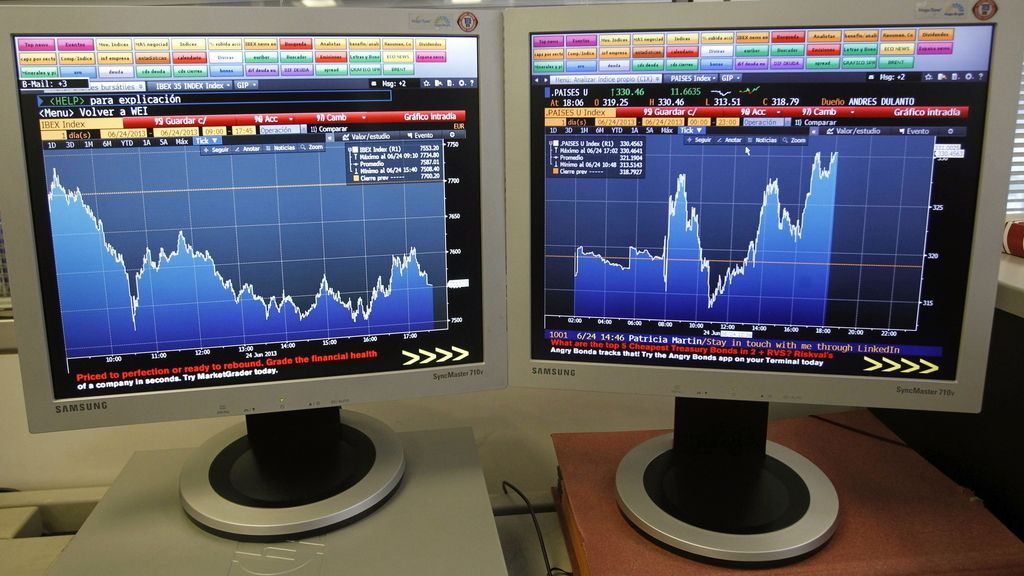 Pantallas que muestran la evolución hoy de la bolsa española (i) y la prima de riesgo