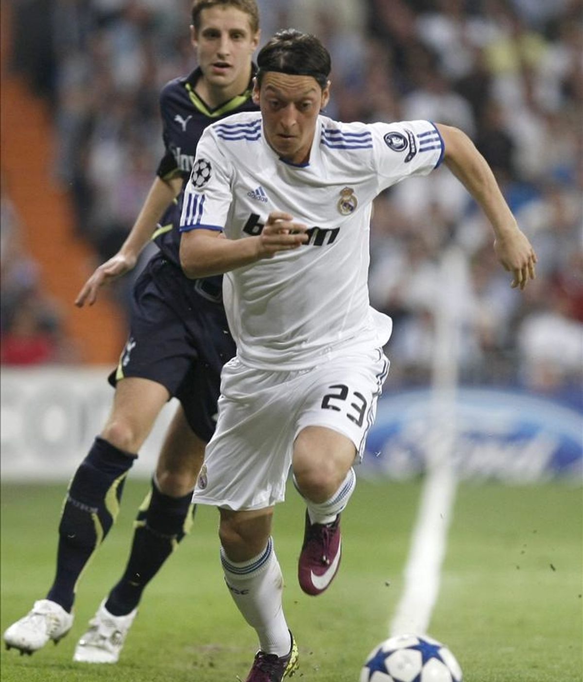 El centrocampista alemán del Real Madrid Özil (d) escapa de Dawson, del Tottenham, durante el partido de ida de los cuartos de final de la Liga de Campeones disputado este martes en el estadio Santiago Bernabéu, en Madrid. EFE