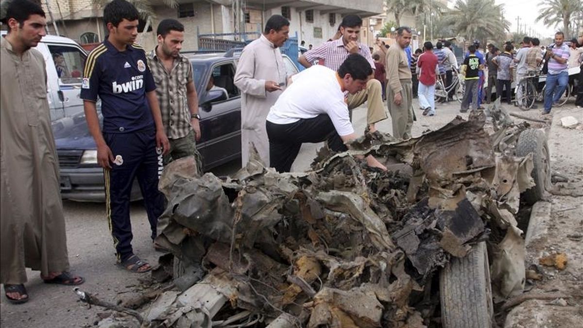 Iraquíes observan los restos de uno de los coche bomba que han hecho explosción en Faluya, Irak. EFE
