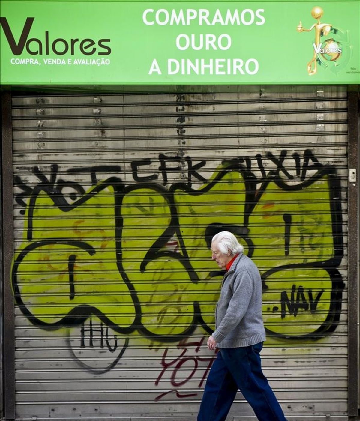 Un hombre pasa frente a un negocio cerrado de Lisboa, Portugal. EFE/Archivo