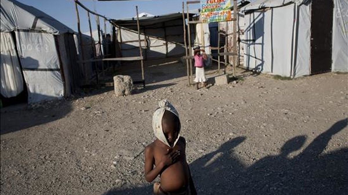 Un niño descansa mientras juega con otros en el campo de desplazados de Aviation, en Puerto Príncipe (Haití). Los haitianos conmemorarán el próximo 12 de enero el primer aniversario del terremoto de 7 grados que dejó más de 300.000 muertos y cambió la historia de este deprimido país. EFE/Archivo