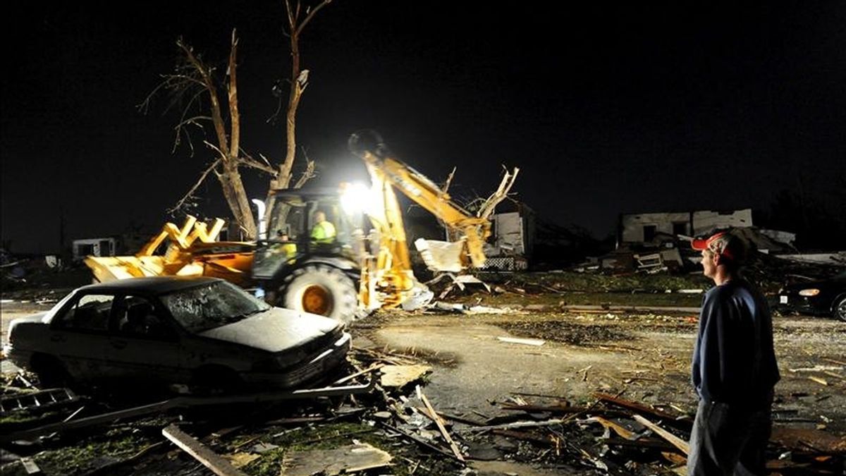 El residente Tedd Grabenauer observa a los servicios de emergencia despejando las calles frente a su casa después de que un devastador tornado asolara la ciudad de Joplin en Missouri (Estados Unidos) hoy, lunes, 23 de mayo de 2011.  EFE