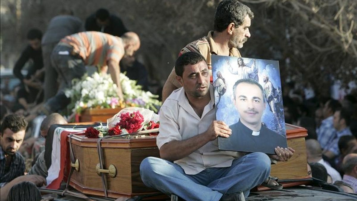 Un hombre iraquí sostiene una fotografía de Wassem Sabeeh, un sacerdote muerto durante la operación de liberación tras el asalto armado a una iglesia católica en el centro de Bagdad, Irak, el pasado 31 de octubre. El dirigente de Al Qaeda Al Batawi era el principal acusado de este atentado, que se saldó con 58 muertos. EFE/Archivo