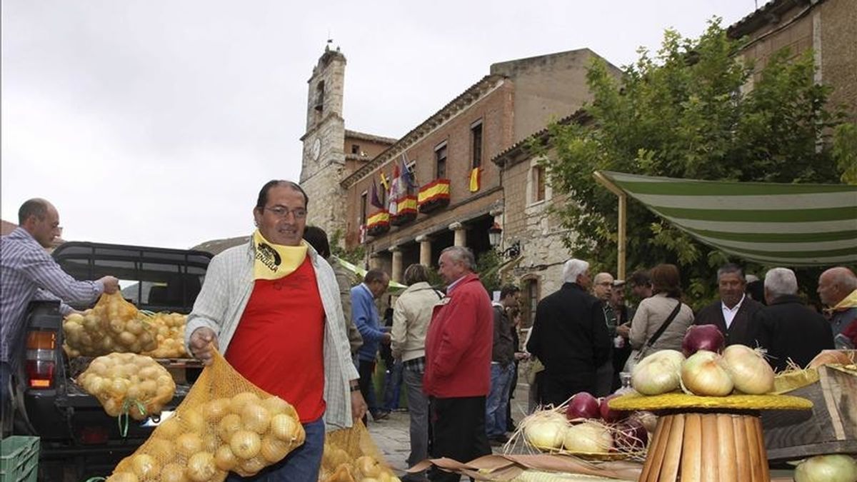 Un agricultor descarga sacos de cebollas en un mercado. EFE/Archivo