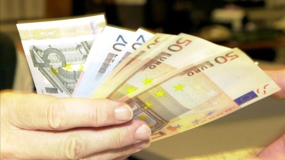 Un empleado de banca muestra unos billetes de euro. EFE/Archivo