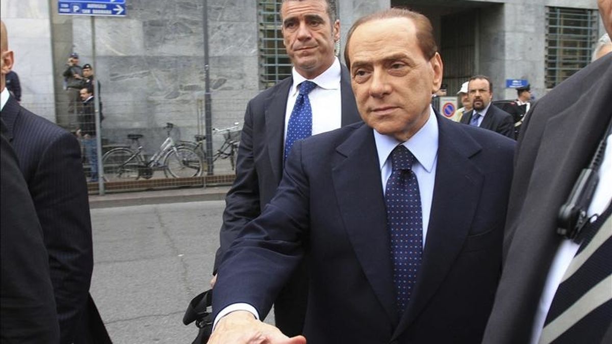 El primer ministro italiano, Silvio Berlusconi (centro), a su llegada hoy al Tribunal de Milán (Italia). EFE