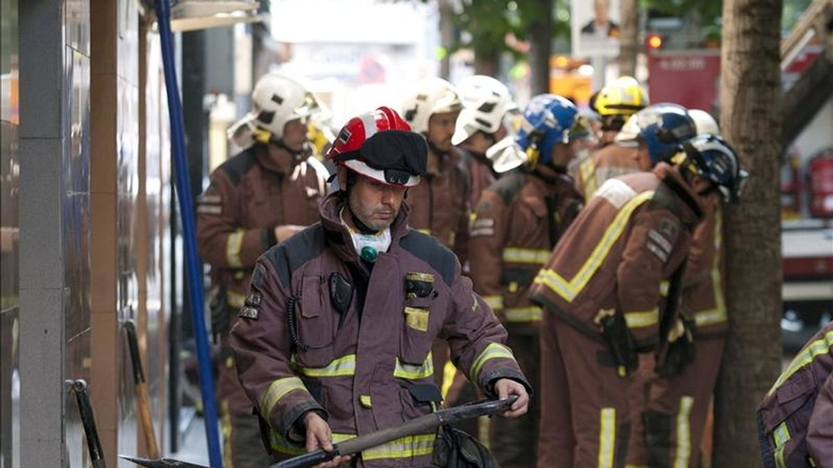 Efectivos de los bomberos y de otros equipos de emergencias trabajan en los escombros de un edificio derrumbado hoy en Santa Coloma de Gramenet (Barcelona). EFE