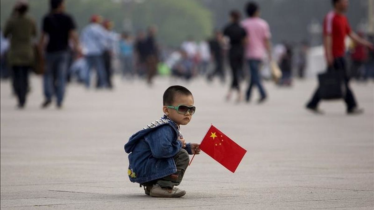 Un niño juega con una bandera china en la plaza de Tiananmen. EFE/Archivo Un niño juega con una bandera china en la plaza de Tiananmen. EFE/Archivo