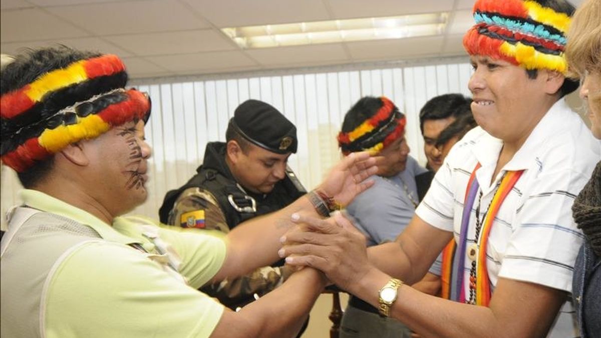 El líder de la etnia shuar José Acacho (d) saluda a otro dirigente indígena en una sala de audiencias en Quito, donde una jueza ecuatoriana ordenó la liberación de los indígenas, Acacho, Pedro Mashiant y Fidel Karinas, detenidos el pasado 1 de febrero. EFE