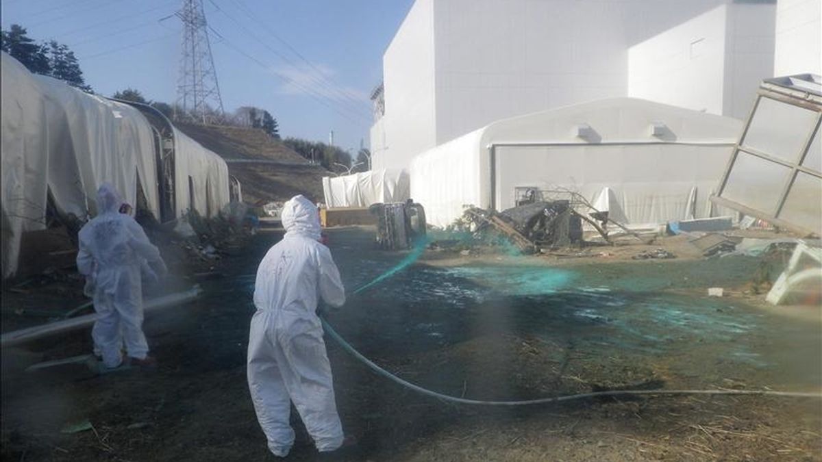 Tabajadores riegan con resina verde a base de polvo protector en el área de una piscina dañada en la planta nuclear de Fukushima Daiichi, al noreste de Japón. EFE/TEPCO