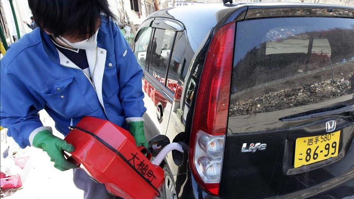Un trabajador llena el tanque de un vehículo con una de las raciones de 20 litros de combustible, hoy en la ciudad costera devastada por el tsunami, de Otsuchi, en la prefectura de Iwate, noreste de Japón. EFE
