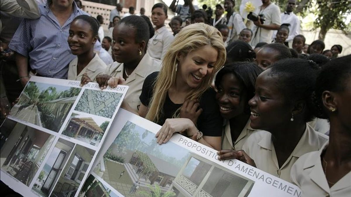La cantautora colombiana Shakira (ci) posa con algunas estudiantes e imágenes de la futura sede de la escuela Elie Dubois el 31 de marzo de 2011, en el centro de Puerto Príncipe. El BID y la Fundación Pies Descalzos de la artista colombiana, donaron 566.000 euros para la reconstrucción de la histórica escuela. EFE