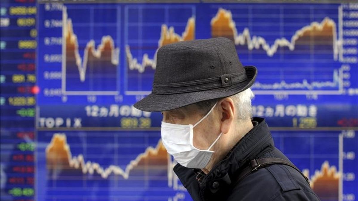 Un ciudadano pasa delante de una pantalla que muestra información bursátil en Tokio (Japón). EFE