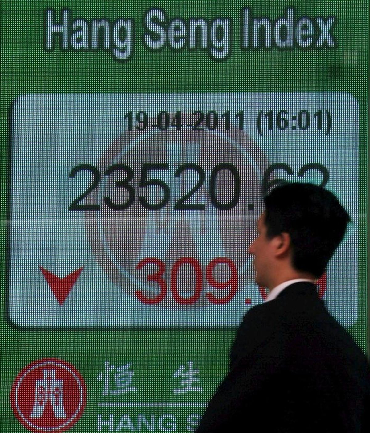 Un hombre pasa delante de un panel electrónico que muestra el valor alcanzado por el índice Hang Seng de la Bolsa de Hong Kong. EFE/Archivo