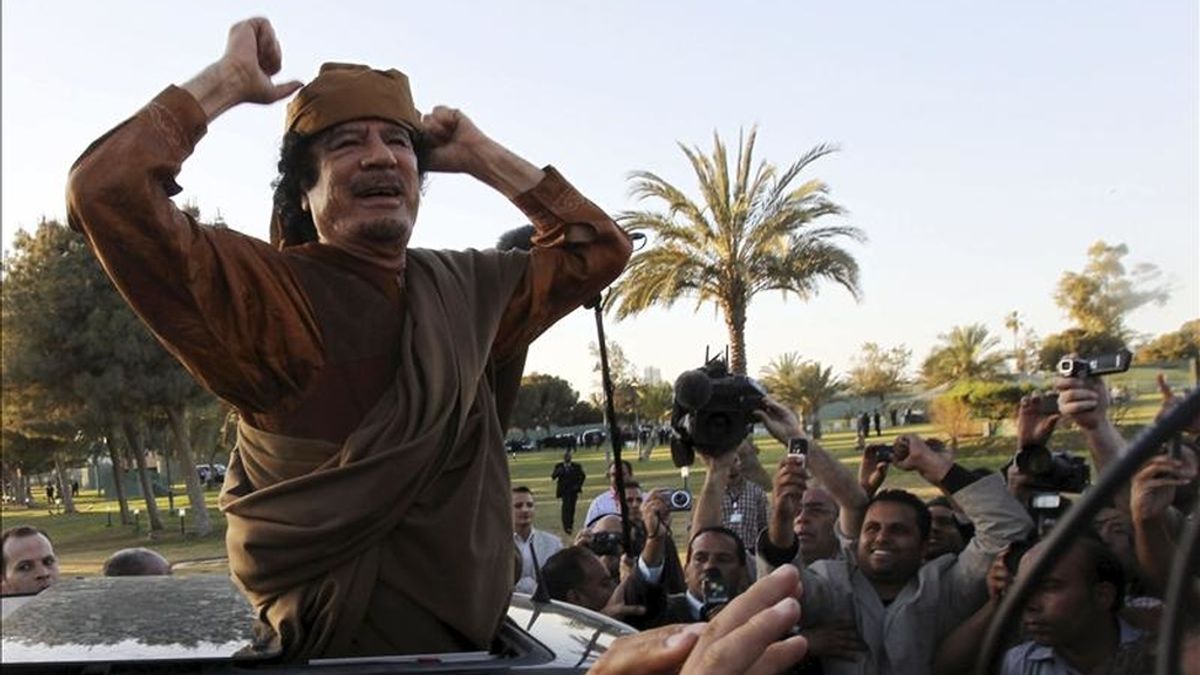 El líder libio Muamar el Gadafi saluda desde un vehículo en el complejo de gobierno de Bab el Azizia, donde Gadafi tiene su residencia oficial, tras una reunión con una delegación de cinco líderes africanos que buscan mediar en el conflicto de Libia, en Trípoli, Libia, el pasado 10 de abril. EFE/Archivo