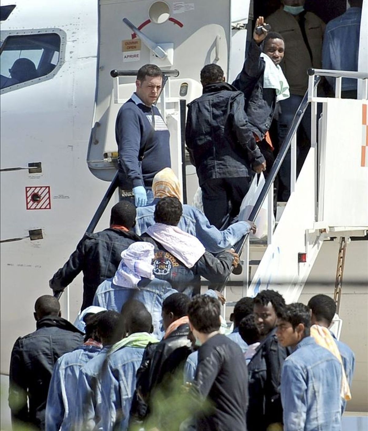 Algunos de los 53 supervivientes del naufragio de ayer en las proximidades de la isla de Lampedusa, embarcan en un avión en el aeropuerto de Lampedusa, Italia. EFE