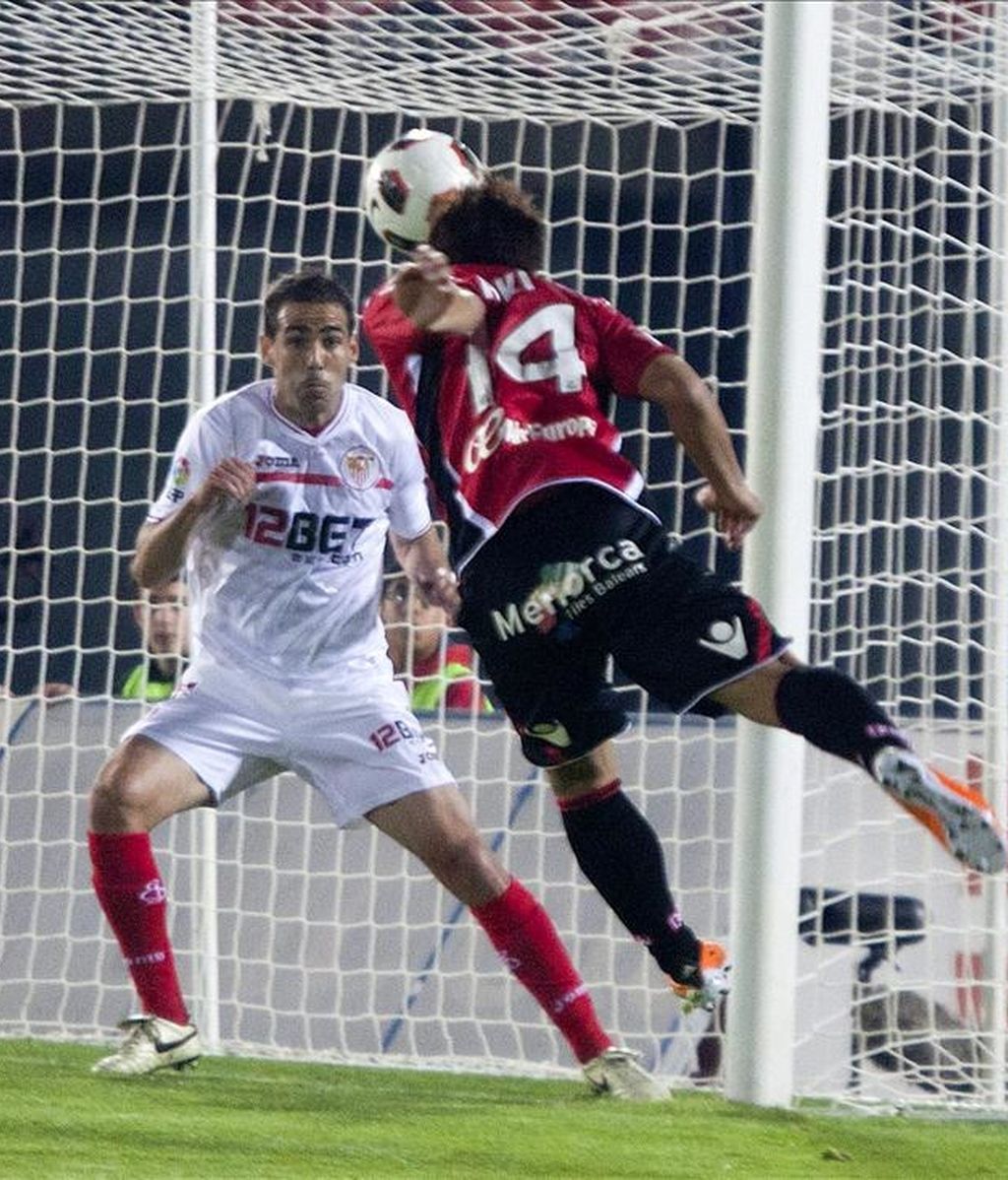 El centrocampista japonés del RCD Mallorca Akihiro Ienaga (d) remata un balón ante el defensa del Sevilla CF Fernando Navarro durante el partido correspondiente a la trigésimo primera jornada del Campeonato Nacional de Liga de Primera División que enfrentó a ambos equipos en el estadio Iberostar. EFE