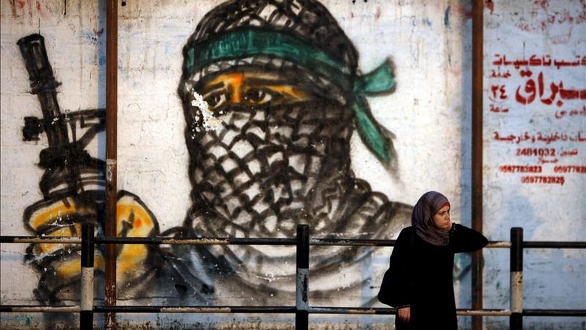 Una palestina espera frente a un mural, en el campo de refugiados de Jabaliya, al norte de la Franja de Gaza. EFE