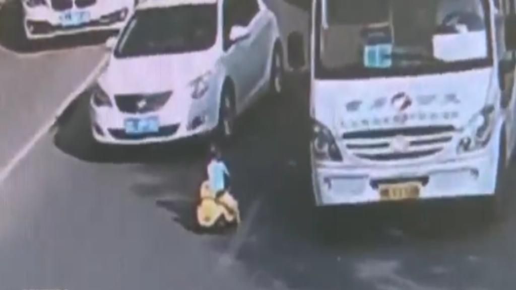 Un niño conduce su coche de juguete en una carretera en China